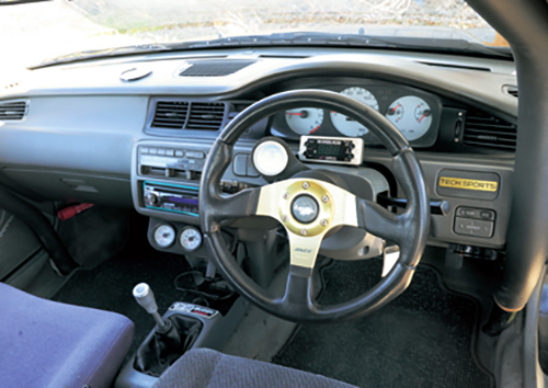 ’90年代初頭のクルマだということがひと目でわかるEG型シビックのインパネ。追加3連メーター、モモの社外ステアリング、シフトノブなどバリバリに手が入れられていた
